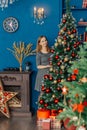 Very beautiful girl stands near the Christmas tree and touches toys. Royalty Free Stock Photo