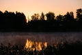 Very beautiful sunrise in summer over a foggy lake. Early morning in summer in nature. Defocused Royalty Free Stock Photo