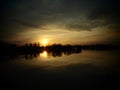 Very beautiful sunset over the water. River bank and horizon. Bright clouds are drawn by the evening sun. Setting sun Royalty Free Stock Photo