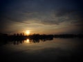 Very beautiful sunset over the water. River bank and horizon. Bright clouds are drawn by the evening sun. Yellow, orange Royalty Free Stock Photo