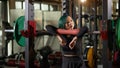 Very beautiful teenage girl resting and getting motivated between sets of barbell squats in gym Royalty Free Stock Photo