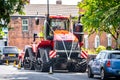 Very big red combine tractor with rubber tracks and massive exhaust as unique individual wedding car with ribbons parked road Royalty Free Stock Photo