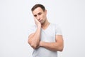 Very bored adult italian man holding hand on cheek, looking tired and sick, Royalty Free Stock Photo