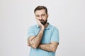 Very bored adult man with beard holding hand on cheek while support it with another crossed hand, looking tired and sick Royalty Free Stock Photo