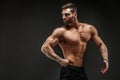 Bodybuilder posing. Fitness muscled man on dark background. Royalty Free Stock Photo