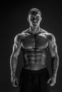 Bodybuilder posing. Fitness muscled man on dark background. Royalty Free Stock Photo