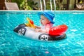 Very cheerful and joyful kid behind the wheel. Summer vacation at sea. A little girl less than one year old is driving an Royalty Free Stock Photo