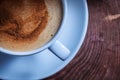 Very close up view from above coffee with foam and cinnamon in white ceramic cup on vintage cross section tree trunk Royalty Free Stock Photo