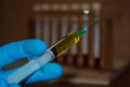 a fiction closeup scene of liquid medical vaccine is in an injector being held by scientist with blue disposable glove