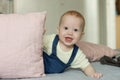 Very curious baby stares while playing with pillows Royalty Free Stock Photo