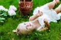 Very cute little blonde girl in a white dress lying on the grass Royalty Free Stock Photo