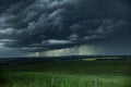 Very dark and dramatic storm clouds over a rape seed field. Royalty Free Stock Photo