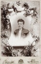 Very decorated cabinet card with a portrait of a woman surrounded by flower decorations from around 1900