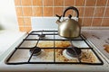 Very dirty gas stove and kettle stained while cooking, a stove covered in grease. Mess in kitchen room