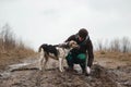 Very dirty and wet mixed breed shepherd dogs standing near faceless owner Royalty Free Stock Photo