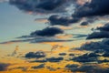 A very dramatic sky full of yellows, blues and oranges. Contrasting clouds during sunset illuminated by the setting sun