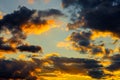 A very dramatic sky full of yellows, blues and oranges. Contrasting clouds during sunset illuminated by the setting sun Royalty Free Stock Photo