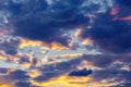 A very dramatic sky full of yellows, blues and oranges. Contrasting clouds during sunset illuminated by the setting sun