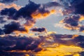 A very dramatic sky full of yellows, blues and oranges. Contrasting clouds during sunset illuminated by the setting sun Royalty Free Stock Photo