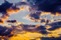 A very dramatic sky full of yellows, blues and oranges. Contrasting clouds during sunset illuminated by the setting sun Royalty Free Stock Photo