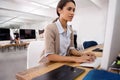 She is a very efficient employee. An attractive young woman working on her computer in an office environment. Royalty Free Stock Photo