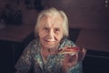 Very elderly woman eating a piece of pizza at home.