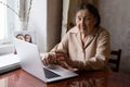 Very elderly woman happily holding a laptop