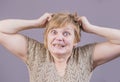 Very emotional angry woman with gold teeth on a gray background. Royalty Free Stock Photo