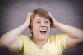 Very emotional woman screams in grief on a gray background Royalty Free Stock Photo