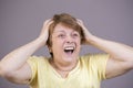 Very emotional woman screams in grief on a gray background Royalty Free Stock Photo