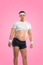 A funny fat man on pink background. Obesity and eating disorder. Concept for dietetics and fitness advertising