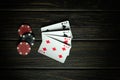 A very gambling game of poker with four of a kind or quads. Red chips and cards on a dark vintage table in a poker club