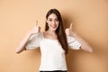 Very good. Happy and satisfied young woman showing thumbs-up, smiling positive, approve and like excellent choice Royalty Free Stock Photo