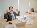 Very Happy asian business man sitting on his desk Royalty Free Stock Photo