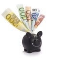 Very happy black piggybank stuffed with various euro banknotes