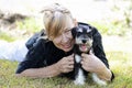 Happy mature senior woman smiling hugging pet puppy dog