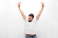 Very happy young man stands and looks down. He keeps hands up. Guy is amazed. Isolated on white background.