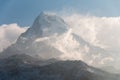 Very high snow mountain peak over the clouds level