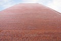 Very high wall of red brick building and cloudy sky Royalty Free Stock Photo