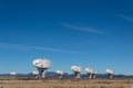 Very Large Array Distant view of numerous dish antennas pointing toward a blue sky, science technology space exploration Royalty Free Stock Photo