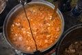 Very large cauldron cooking food during campfire. Cooking in a pot on the fire. Camping concept