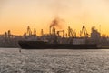 A very large container ship sailed to load containers at the industrial sea port. The ship is transport. Cranes load cargo Royalty Free Stock Photo