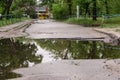 Very large, deep pit with water for the entire width of the road after the sewer repair.