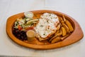 A very large dinner portion on a wooden plate. meat dish with salad