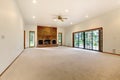 Very large empty living room with brick fireplace.