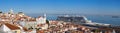 Very large panoramic view on Sao Vicente de Fora church, red roofs on Lisbon centre and big cruise liner ship on Tagus River