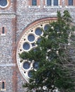 Very large round window in a cathedral, green tree in front of it