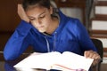 Very listless girl reluctantly studying a textbook