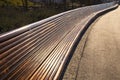 Very long empty wooden bench