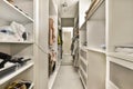 a large walk in closet with white cabinets and shelves